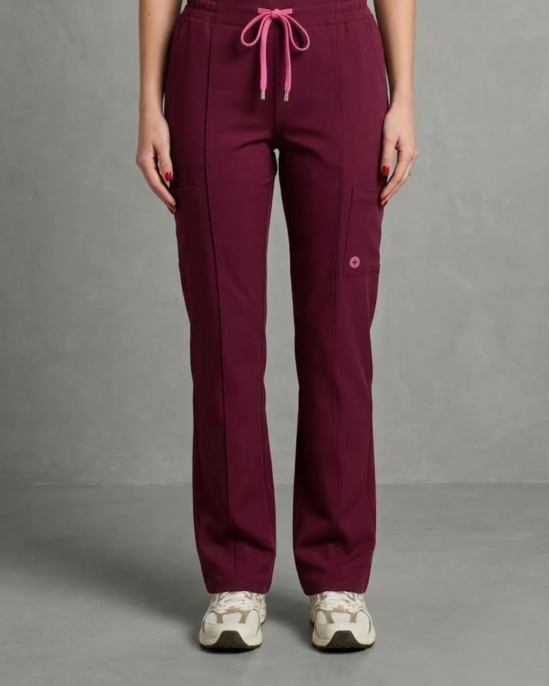 Maroon pants with pink drawstring and buttons on a gray background