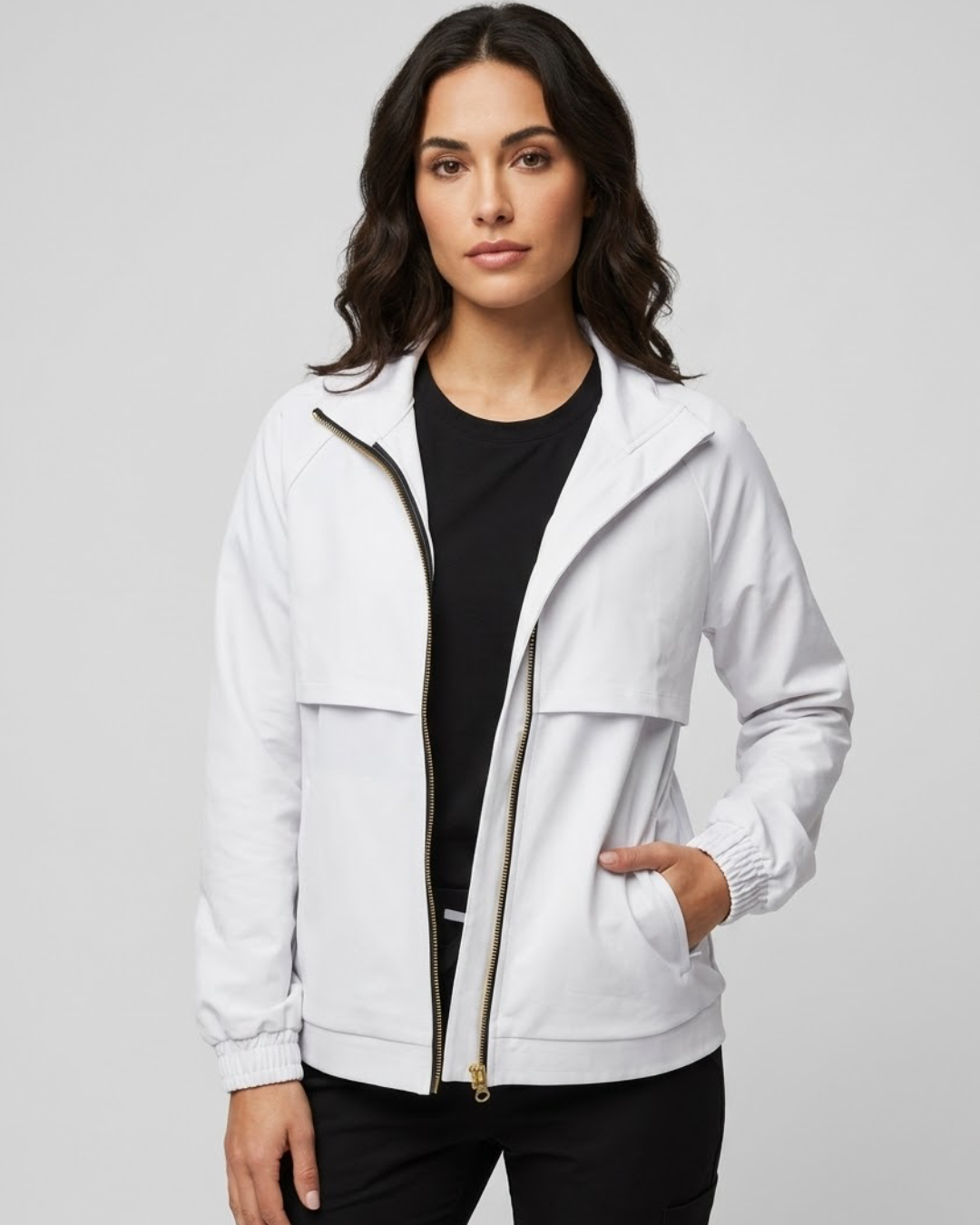 Woman wearing a white jacket over a black shirt on a gray background