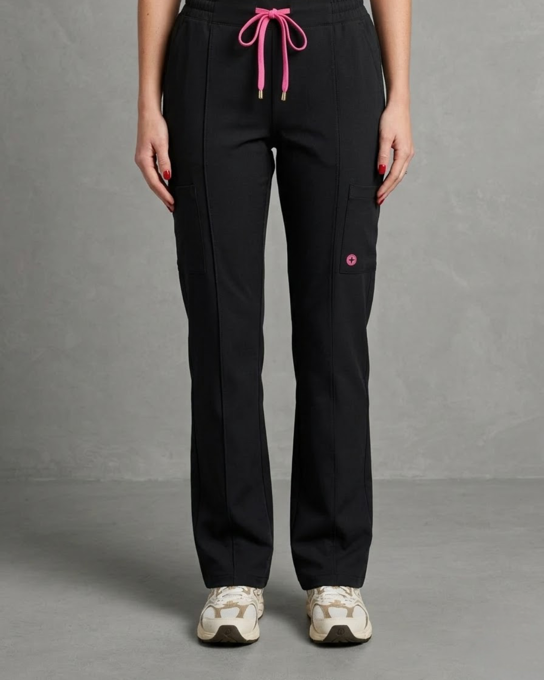 Black pants with pink drawstring and small pink detail on a gray background