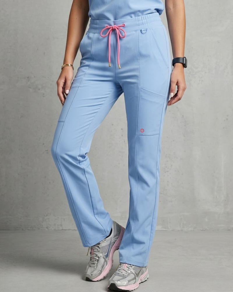 Light blue scrubs with pink drawstring and sneakers on a gray background